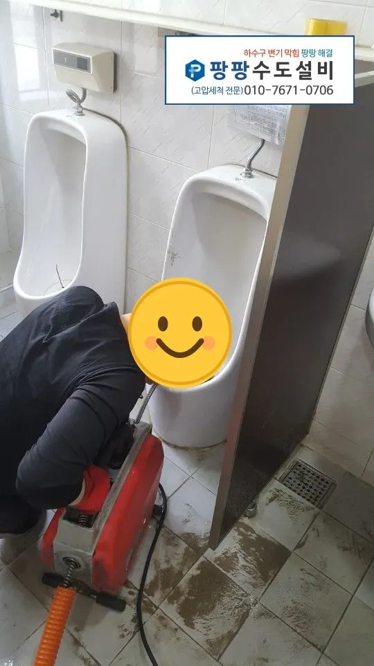 소변기 배수구를 살피며 스프링을 넣는 모습